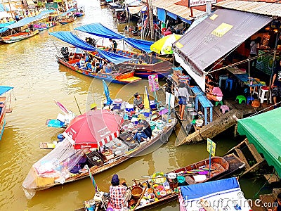 SAMUT SONGKHRAM, THAILAND â€“ JUNE 10, 2018 : Wooden boats busy ferrying people at Amphawa floating market on June 10, 2018. Editorial Stock Photo